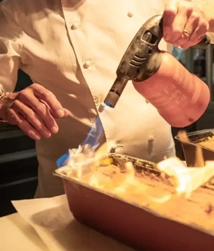Flambage d’un dessert pendant un cours de cuisine privé